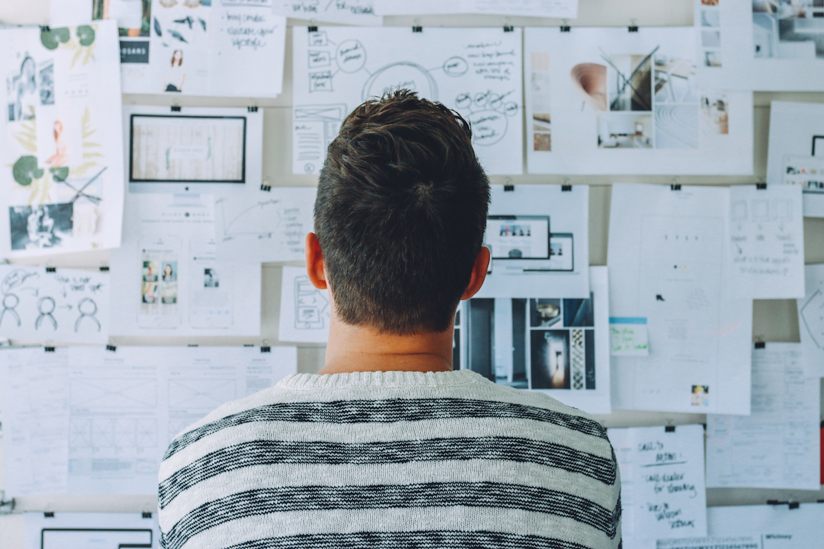 Man looks at wall with spreadsheets and charts. How do you find early adopters?